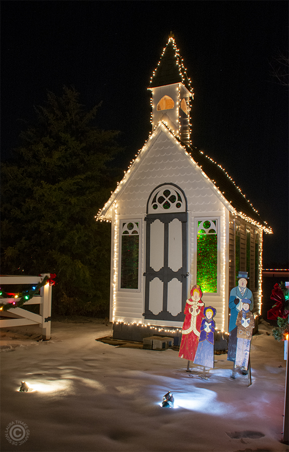 A little country Church with Christmas carolers in front.