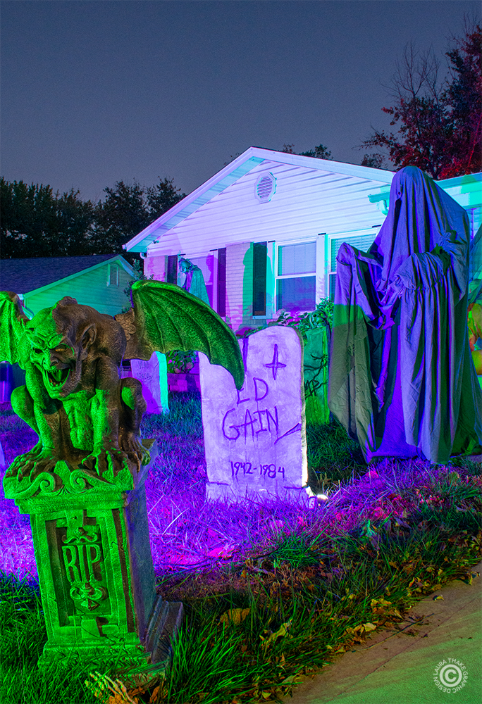 A grim reaper waiting in the cemetery for someone to talk to.