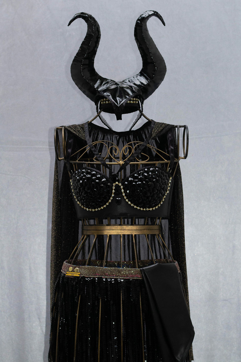 Miniatura: Fantasia Malévola moderna com chifres, capa e brilho sofisticado