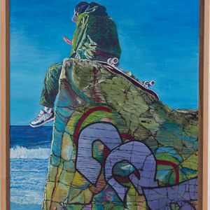 Un skater se repose sur un blockhaus. Face à la mer il a le regard rivé sur l'écran de son smartphone.