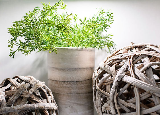 Glass upper kitchen cabinets are styled with warm wood accents and greenery