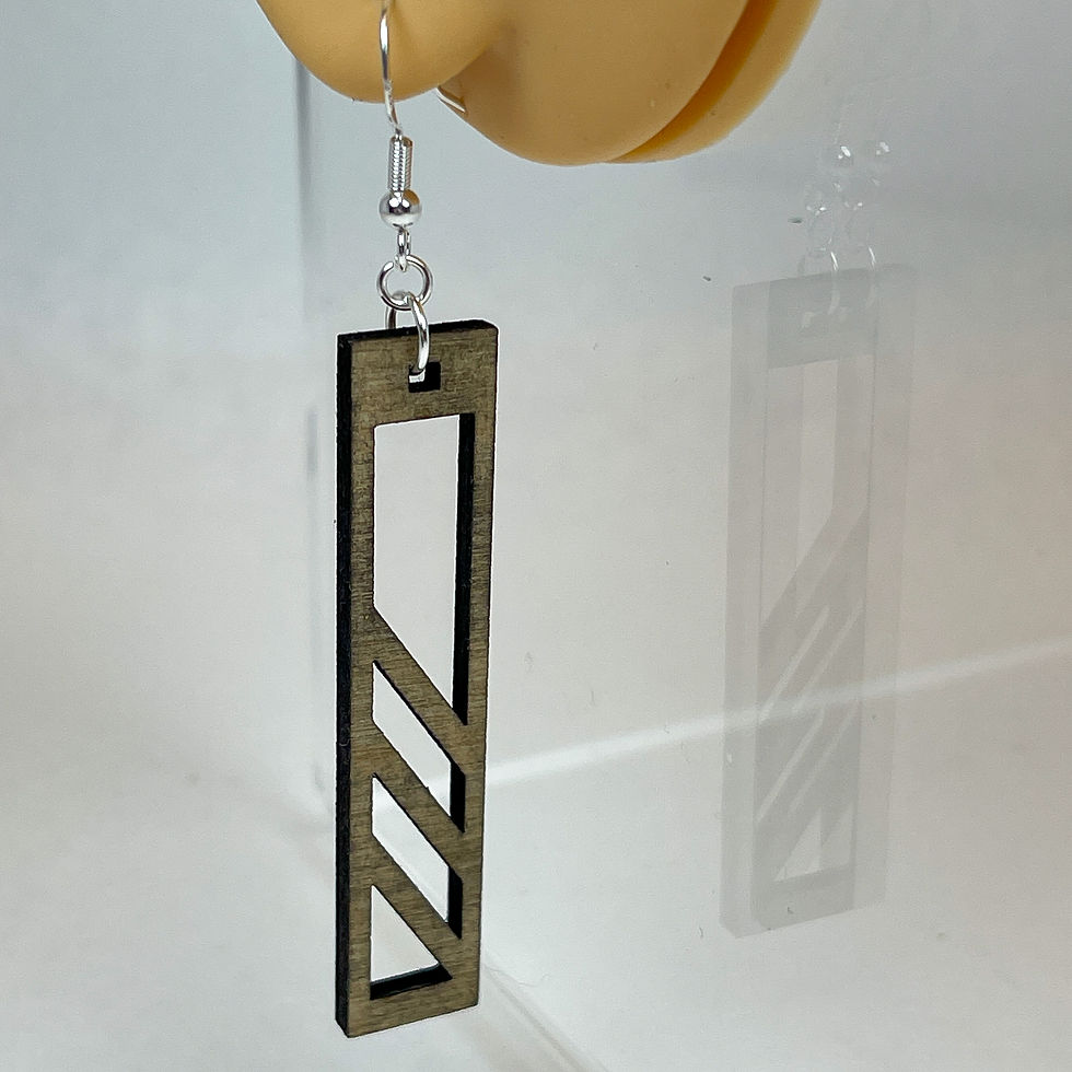 Thumbnail: Handmade wooden rectangular shaped dangle earrings with geometric shapes cut out of them.