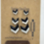 3 pack of glossy handmade wooden earrings in a minimalistic chevron shape.  This stud is black on top and white on bottom..