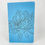 Thumbnail: Handmade saddle bound notebook with hand drawn inked flowers on a blue cover.