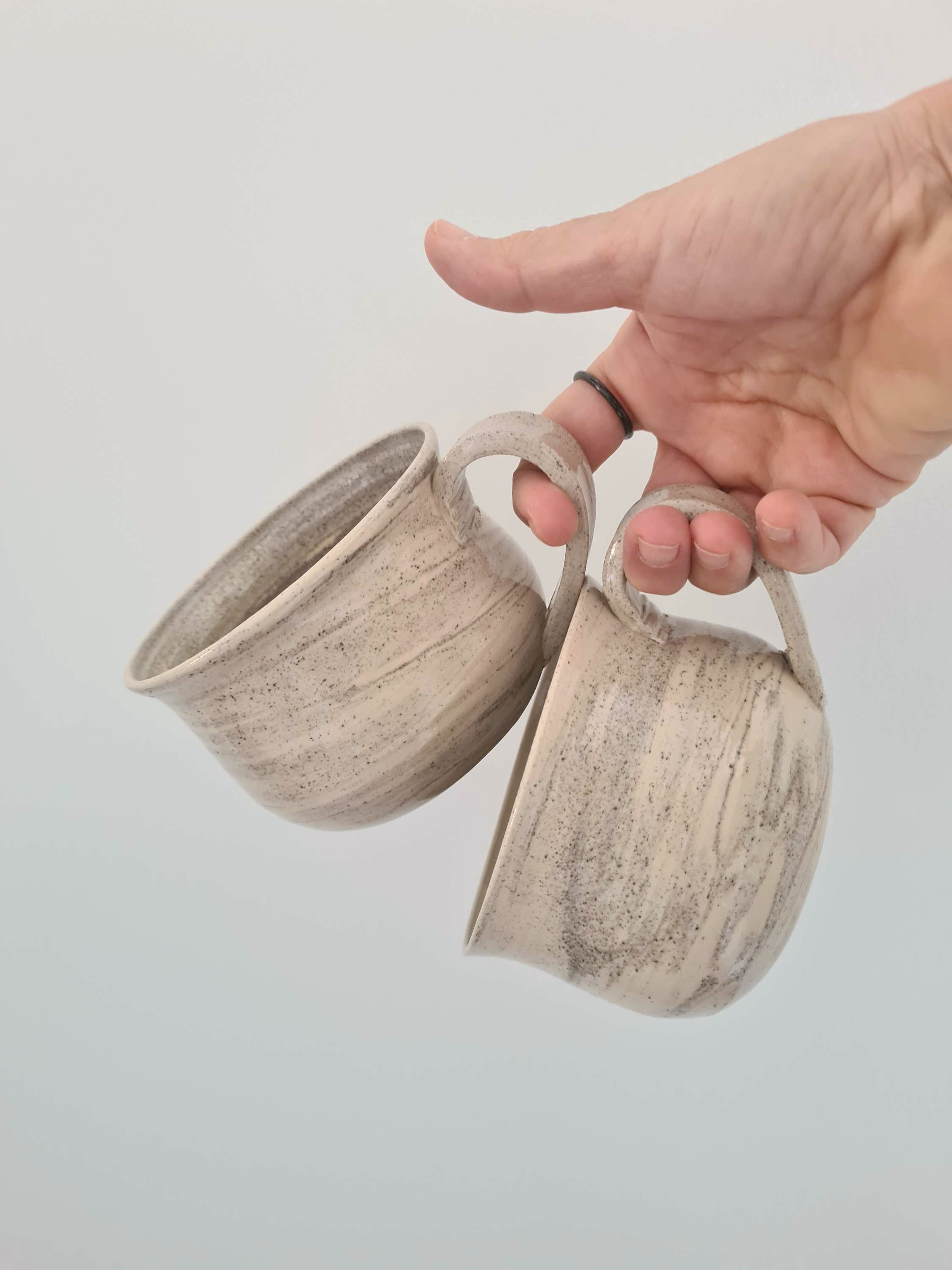 שני מאגים מחימר מעורב לבן ואפור דגם שיש עם ידית בזיגוג ושקוף מבריק