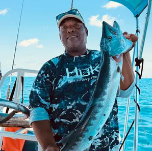 Captain holding a barracuda on a cook your catch tour Belize