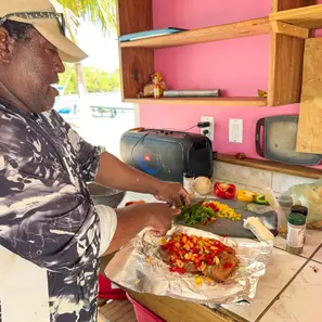 Captain preparing the fish before placing it on the grill for the cook your catch tour belize