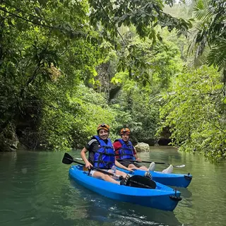 Guests kayaking through rainforest between caves on the Caves Branch River