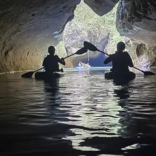 Beams of sunlight lighting up a limestone cave on a Caves Branch kayaking tour from Placencia, Belize