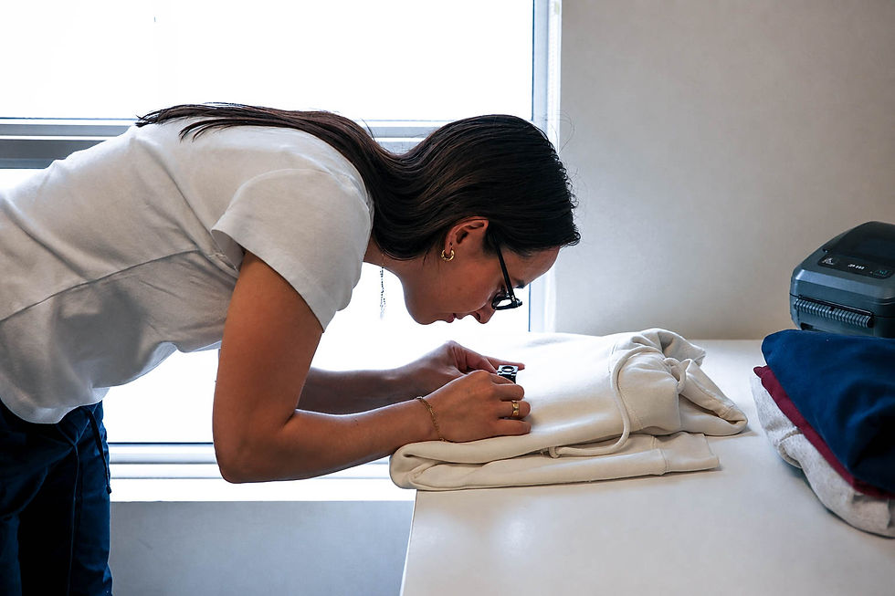 Image of a woman inspecting a hoodie