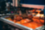 Image of a screenprinting machine applying orange ink onto a screen,