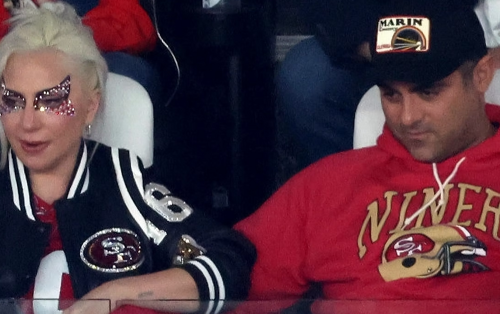 Si Lady Gaga ug iyang fiancé nga naglingkod nga magtapad atol sa usa ka sporting event.