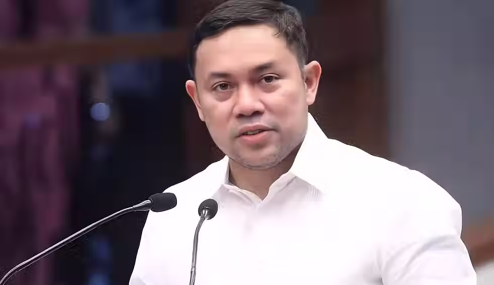 Hulagway ni Senador Mark Villar nga nagsul-ob og puti nga polo samtang nagpamulong atubangan sa mga mikropono.
