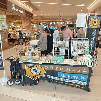 自主製品販売強化実行委員会 （部会）では、スマイルガーデンホドガヤとして、
毎月１回、原則第３水曜日にイオン天王町ショッピングセンター１階南東側（天王町商店街側）入口近くで販売活動を行っています。販売時間は11時から14時です。

最近では毎回６～８事業所が参加してにぎやかに活動しています。ポイントカードもお配りしていて、10ポイントたまると景品を差し上げています。
おかげさまで、リピーターのお客様も増えています。５月にはイオン天王町ショッピングセンターの200日祭に加わらせていただきました。
次回は９月20日（水）に、６事業所が参加する予定です。ぜひお立ち寄りください。