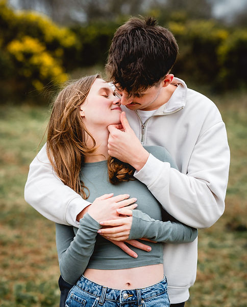 An engaged couple kissing during a winter walk in Somerset.