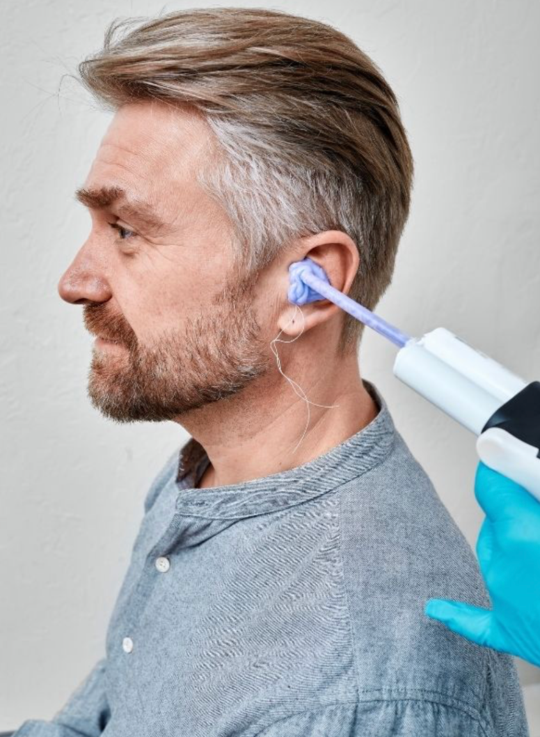 Dr Haynie taking impressions for custom ear mold