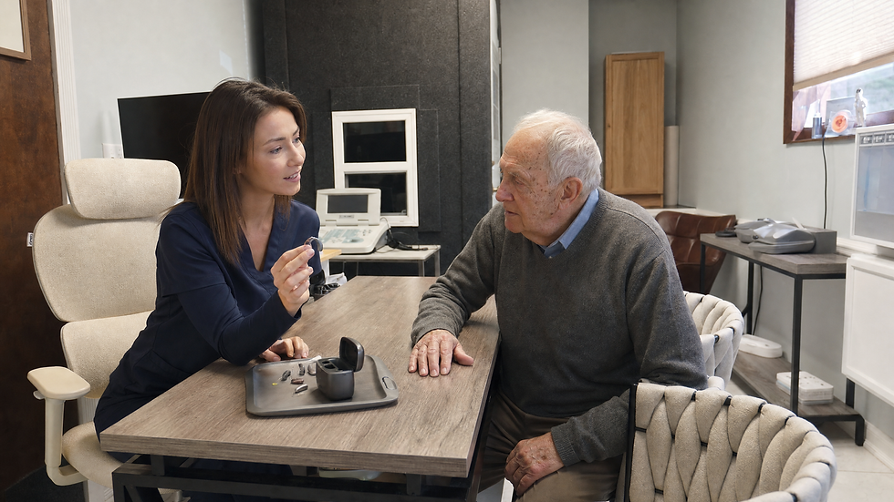 Dr Haynie showing a patient hearing aids during a hearing aid evaluation