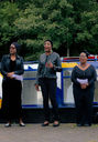 The Word Life Corral, three middle aged Black women all dressed in black, perform song 'Firmament'. Behind them is the blue-and-yellow Ikon slow boat. 