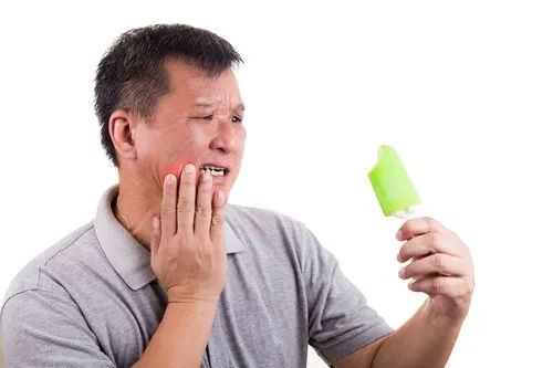 a man eating an ice cream and having a toothache