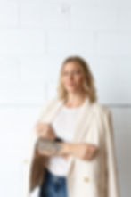 Image of Dr. Caitlin Sembach standing near a wall with her arms folded and looking at the camera.