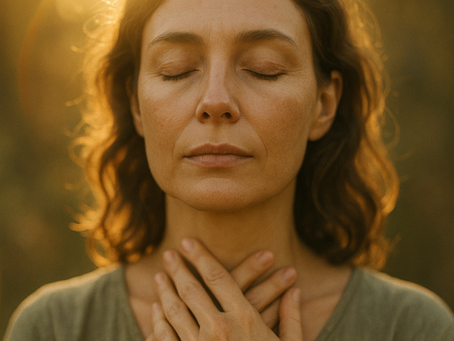 Woman in soft light with her hands over her throat