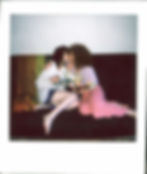 lesbian couple in an embrace kissing on sofa holding flowers as in reconciliation