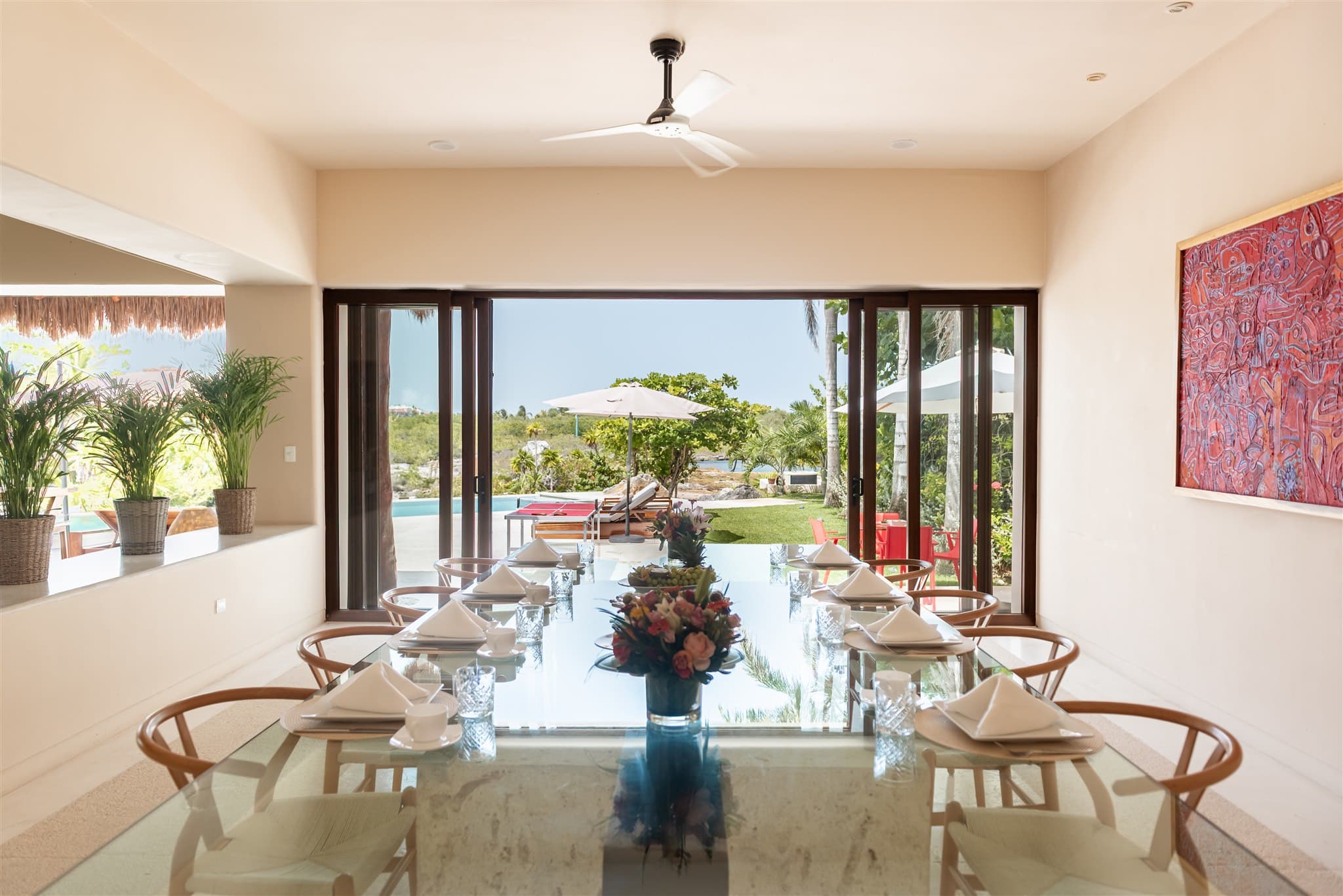 Dining room opening directly onto the pool and the water