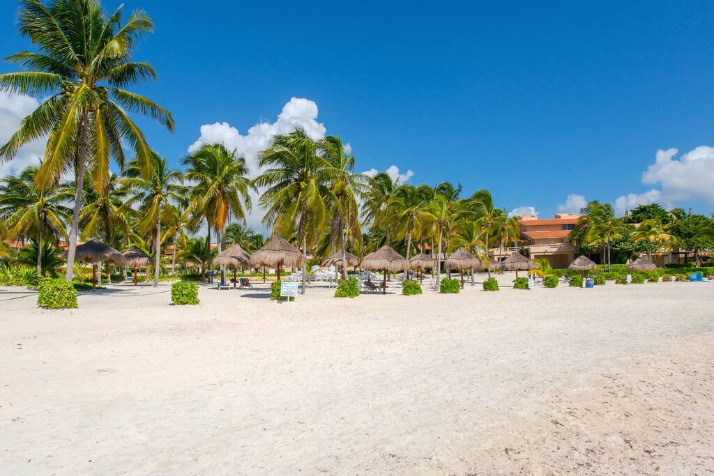 Villas del Mar: palapa and loungers on the white sand facing the bay