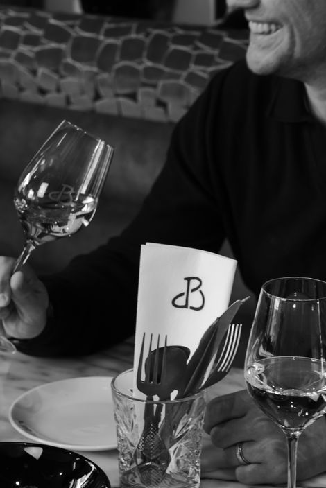 Sfeervolle fotografie van een restaurant en wijnbar met gerechten en wijnen.