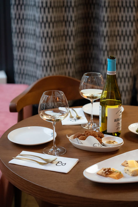 Sfeervolle fotografie van een restaurant en wijnbar met gerechten en wijnen.