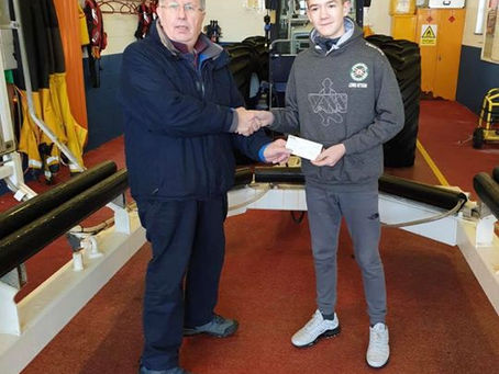 Federation youth member Lewis Kitson delivers a cheque to RNLI