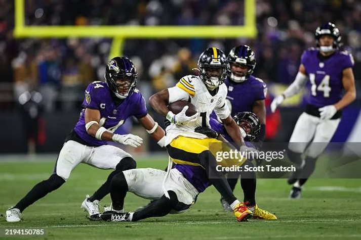 BALTIMORE, MD - JANUARY 11: George Pickens #14 of the Pittsburgh Steelers makes a catch against Brandon Stephens #21, Marlon Humphrey #44, Roquan Smith #0, and Kyle Hamilton #14 during the second half of the AFC Wild Card Playoff game at M&T Bank Stadium on January 11, 2025 in Baltimore, Maryland. (Photo by Scott Taetsch/Getty Images)