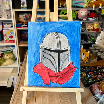 Gemalter Mandalorian-Helm auf Staffelei bei Kreativ-Event