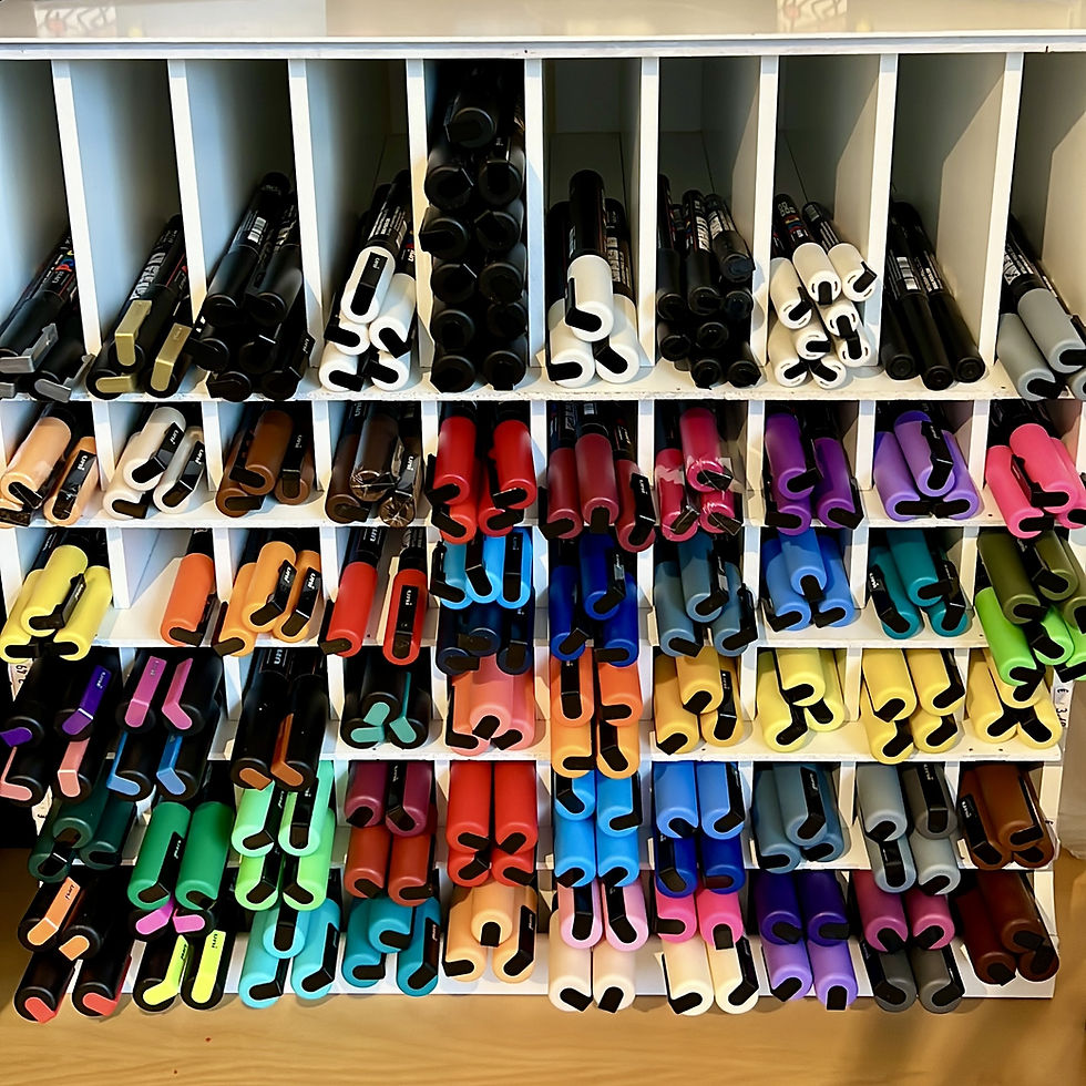 Sortierte bunte Stifte in einem weißen Regalsystem.