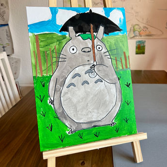 Gemaltes Totoro-Bild mit Regenschirm auf einer Staffelei.