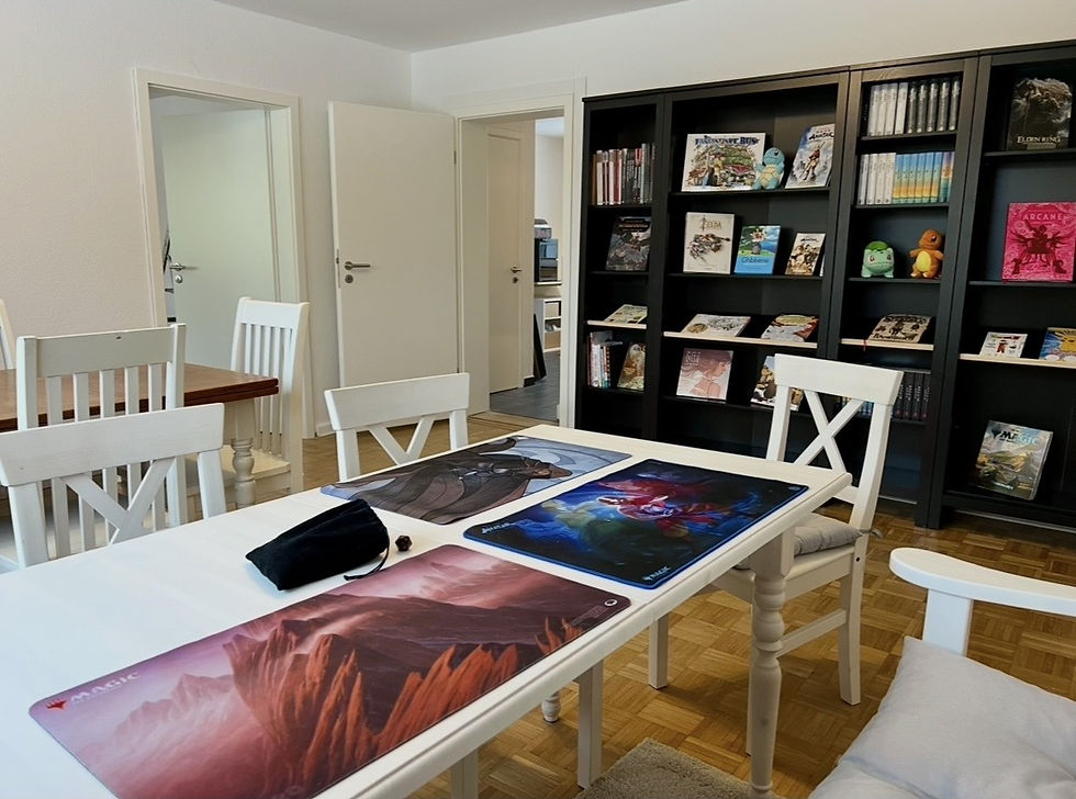 Heller Besprechungsraum mit weißem Tisch und schwarzem Regal.