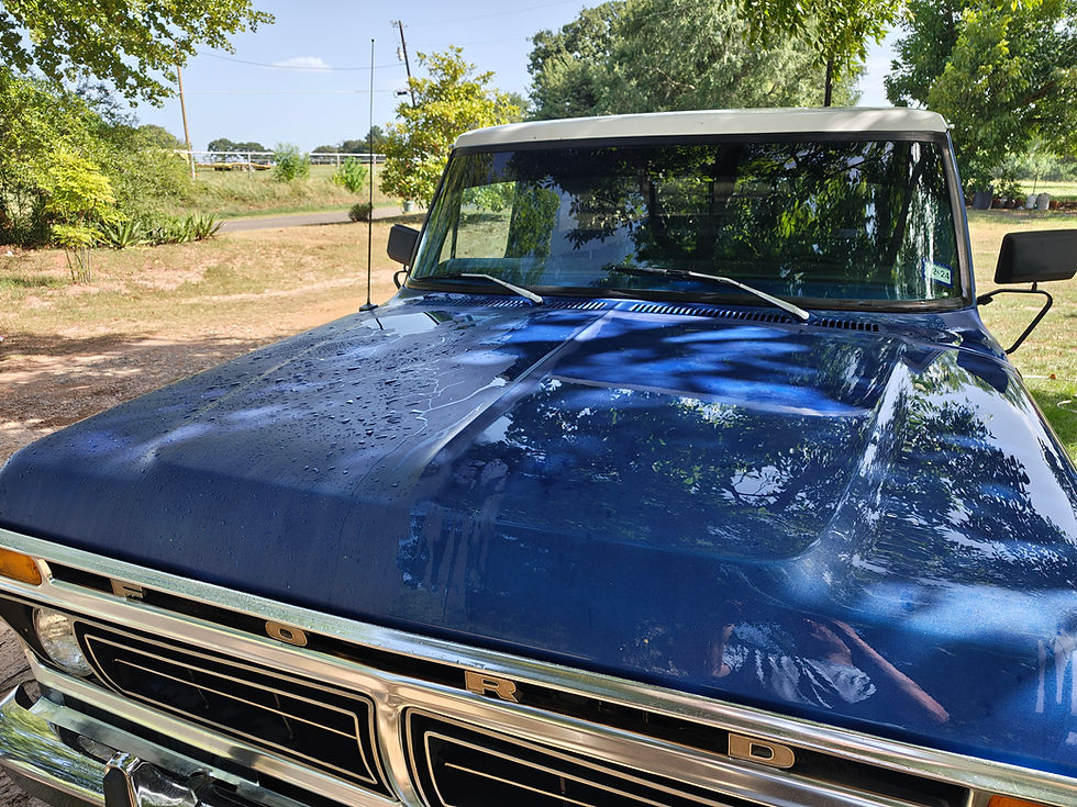 Close-up of a blue vintage Ford pickup truck hood.