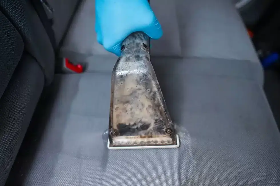 Professional steam cleaning of a grey fabric car seat.