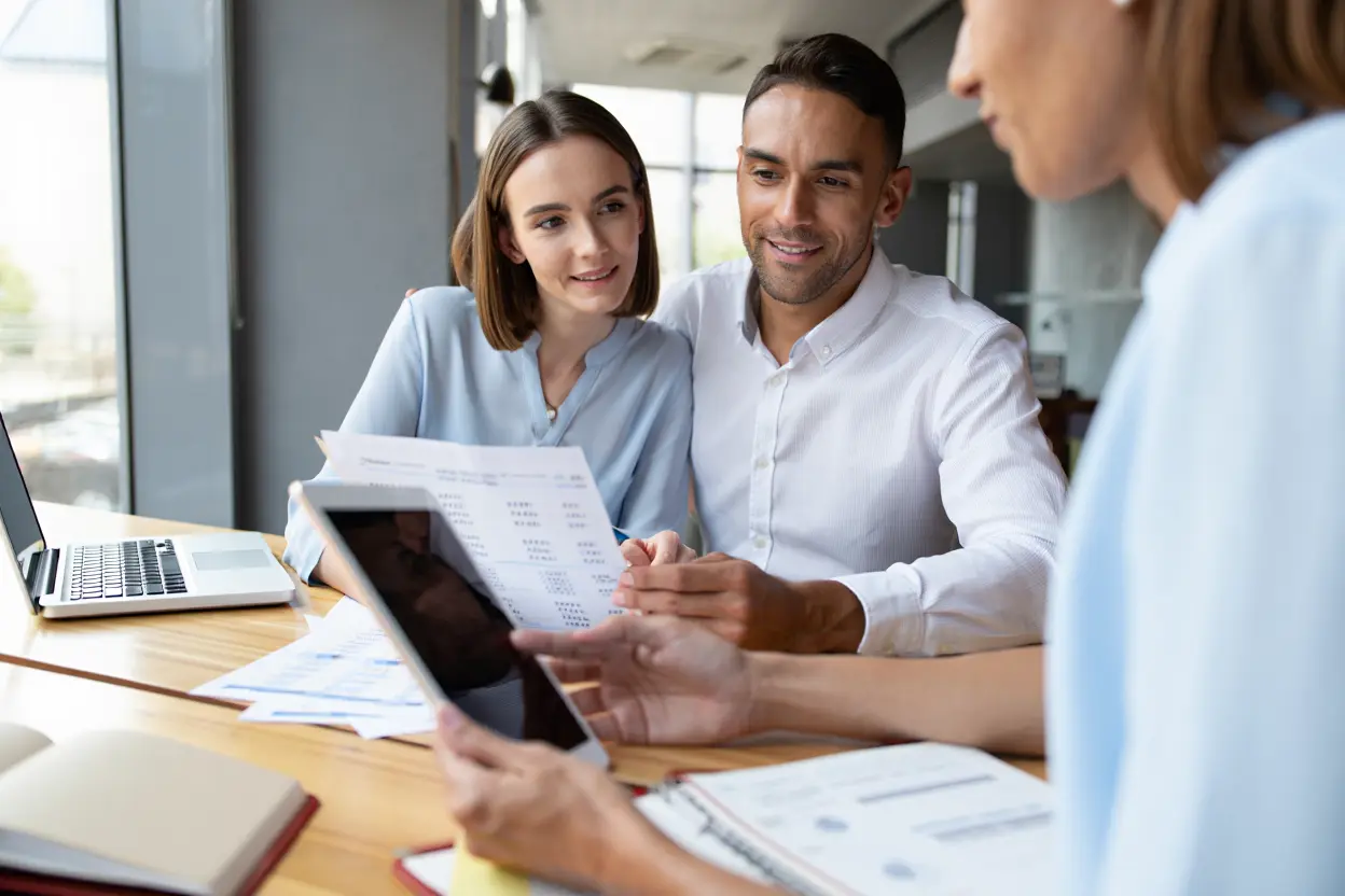 Couple échangeant avec un conseiller bancaire sur des documents financiers