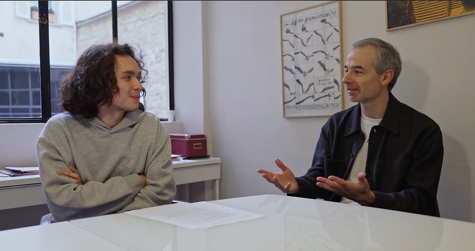 Deux hommes se parlent autour d'une table.