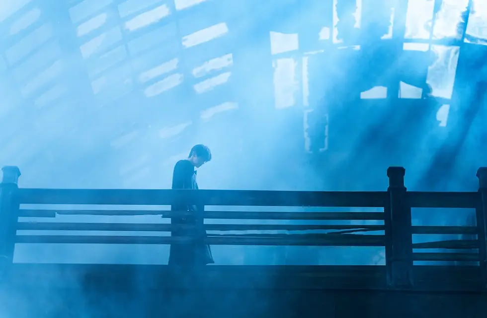 Un homme la tête vers le bas sur ce qui semble être un bon, dans un environnement enfumé et bleu