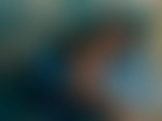 Un homme tient dans ses bras une femme dans leur lit, éclairés par une lampe de chevet