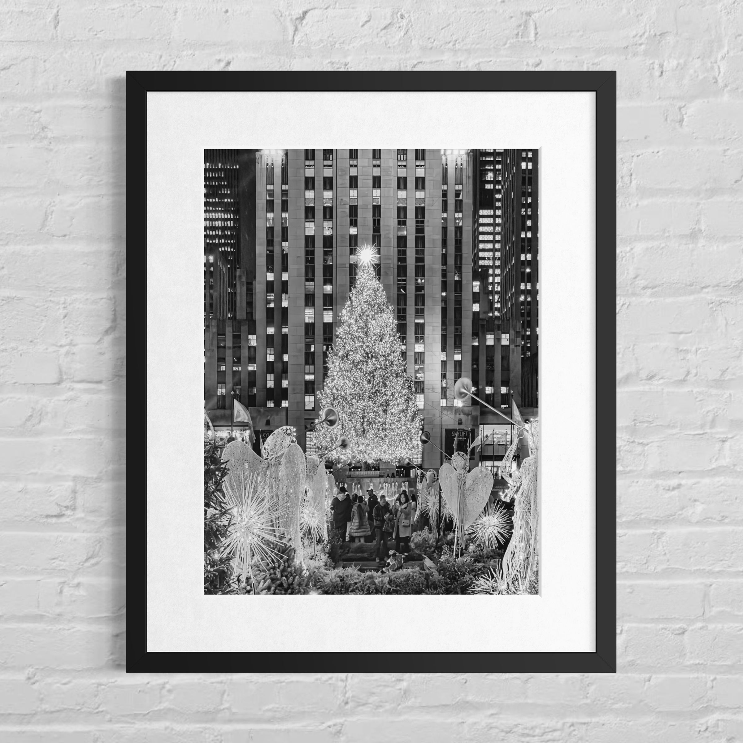 Schwarz‑Weiß‑Ansicht des Rockefeller Center Christmas Tree in New York mit festlicher Beleuchtung und urbaner Kulisse