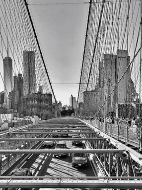 Schwarzweißfoto: Blick von der Brooklyn Bridge auf den Verkehr und die Skyline von New York City