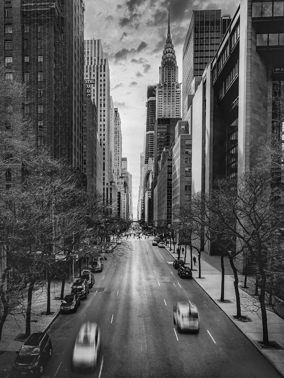 Schwarzweißfoto: Blick entlang einer New Yorker Straße mit Chrysler Building