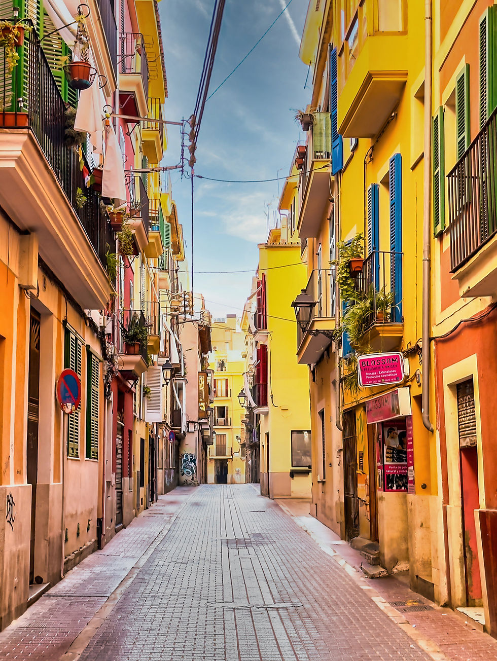 Sonnige, farbenfrohe Straße in Spanien; bunte Häuser