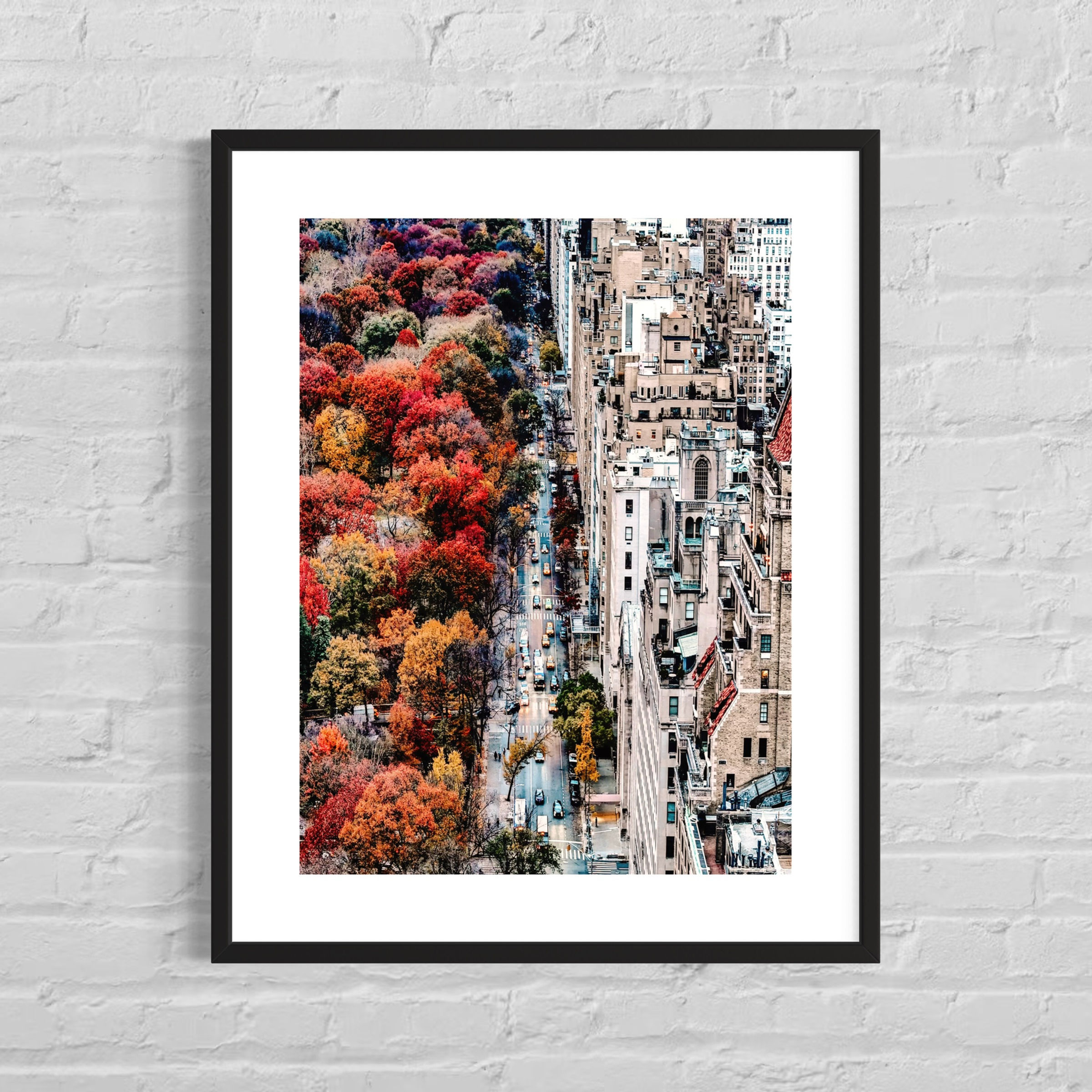 Blick auf Straße neben Central Park, eingerahmt von buntem Herbstlaub und hohen Wohngebäuden in New York