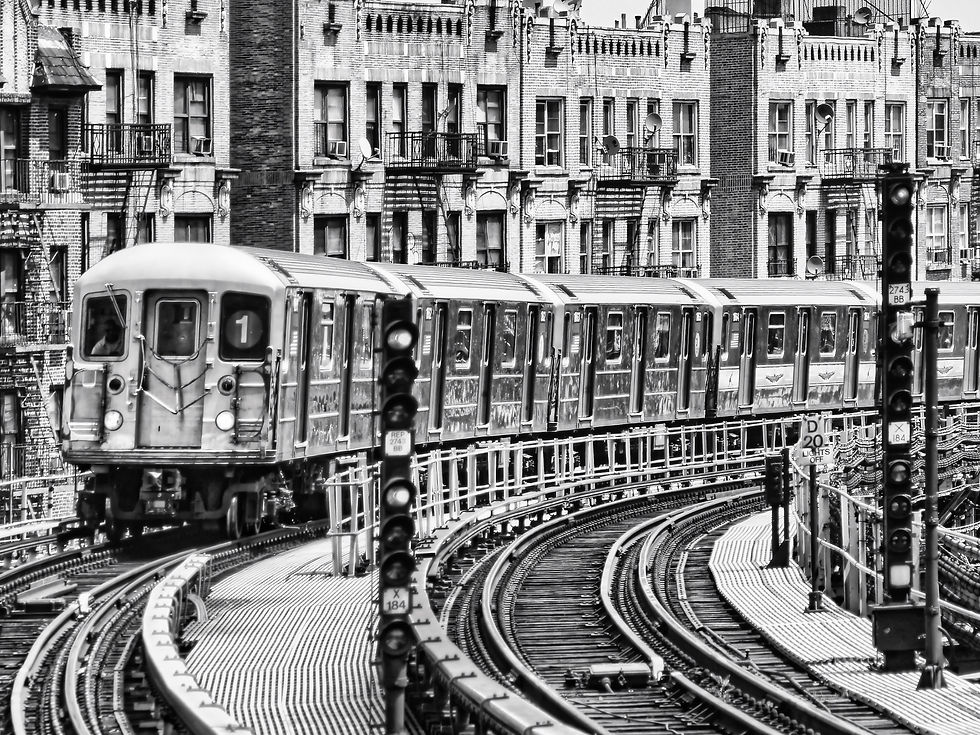 Schwarz-weiß Foto: U-Bahn-Zug fährt an Häusern vorbei