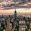 Miniaturbild: Empire State Building leuchtet blau über der abendlichen Skyline New Yorks mit dramatischen Wolken