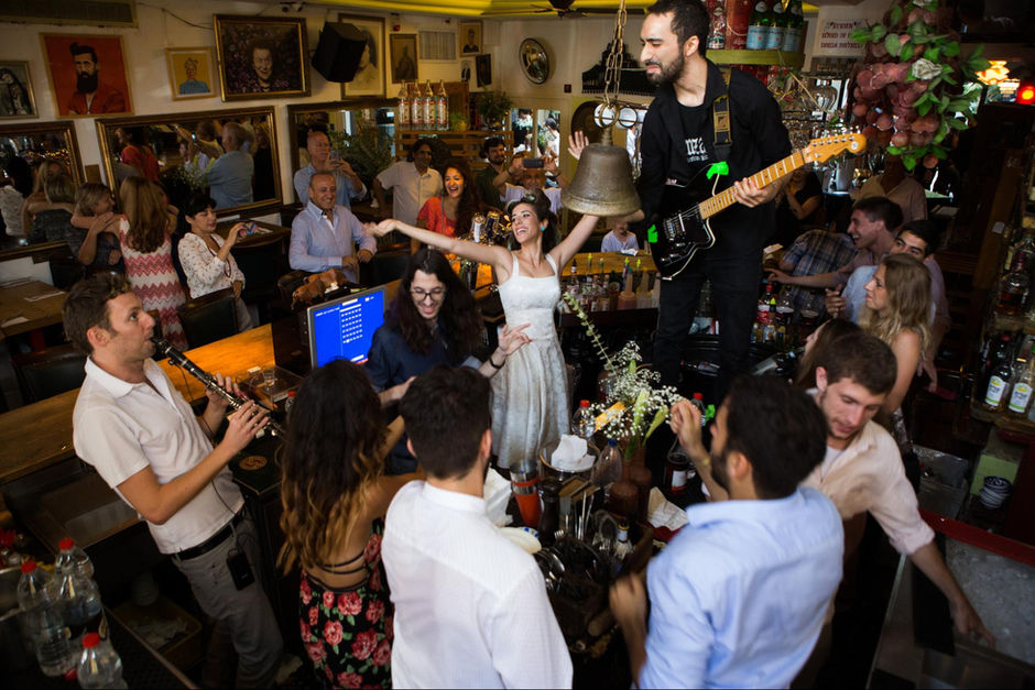 A dancing couple and a live band in a crowded bar. wedding photography